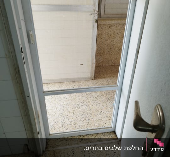 דלת עם תריסים לבנים פתוחים למחצה